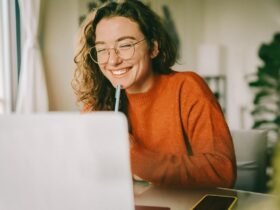 Young woman smiling while looking at laptop screen